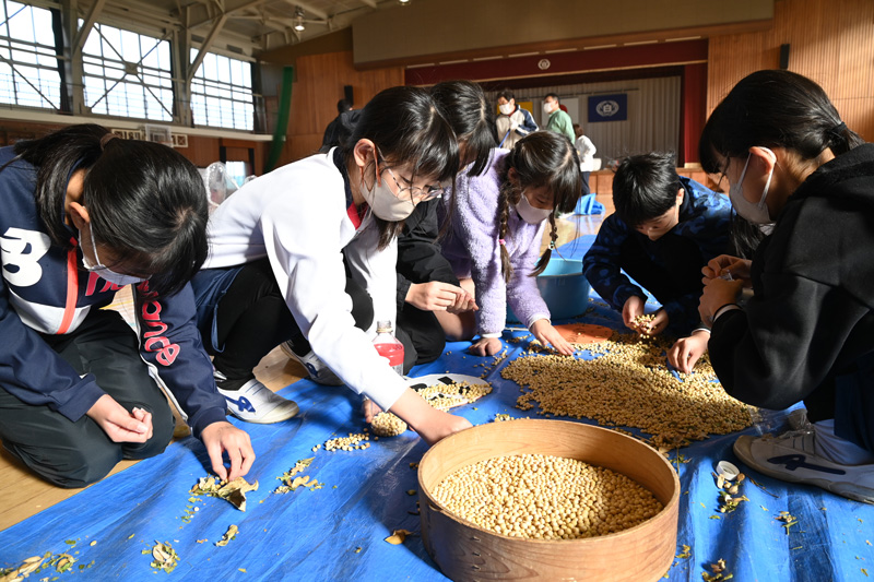 白須賀小の児童と大豆の脱穀